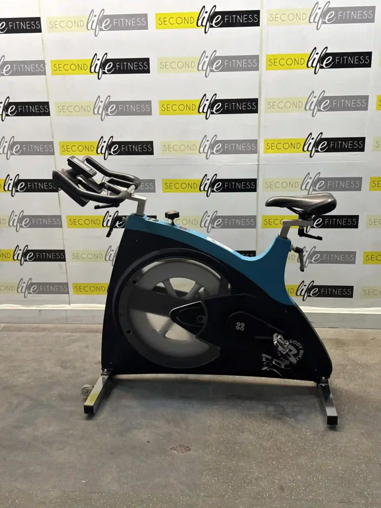 A dynamic shot of a cycling class in a well-lit Sharjah studio, featuring multiple BODY BIKE Connect bikes with riders focused on their performance metrics displayed on the consoles, highlighting its suitability for professional, data-driven group training in the UAE.